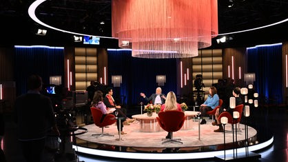 Sechs Frauen sitzen in einem Studio kreisförming zugewandt und sprechen miteinander