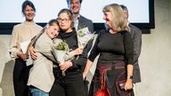 Das WDR-Autor:innenteam Christoph Goldbeck und Ilka aus der Mark mit Marie bei der Preisverleihung am 8. November 2023.