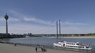 Spaziergänger auf der Rheinuferpromenade. Im Hintergrund Rheinkniebrücke und Fernsehturm (Rheinturm) sowie das Ausflugsschiff "Heinrich Heine" der Köln-Düsseldorfer 