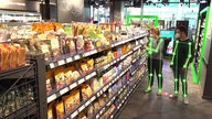 Das Bild zeigt zwei Kund:innen im videoüberwachten Supermarkt.
