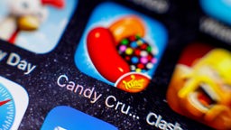 Das Bild zeigt eine Handydisplay mit dem Spiel "Candy-Crush".