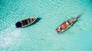 Auf dem Bild sind zwei Boote im Meer zu sehen.