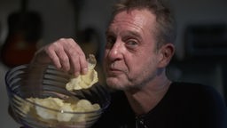 Ein Mann posiert mit einer Schüssel Chips
