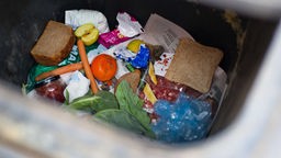 Verschiedene Lebensmittel in einer Mülltonne