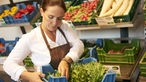 Margarete Ribbecke packt Gemüsekisten für ihre Kunden.