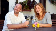 Kathrin Otte und ihr Freund Christoph trinken ein Glas Weißwein.