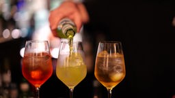 Drei klassische Sommergetränke werden in Gläser gefüllt.