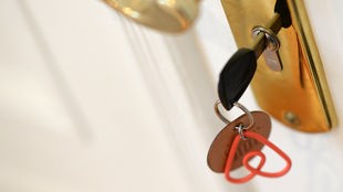 Ein Schlüssel mit Air BnB Schlüsselanhänger steckt in einem Türschloss.