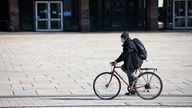 Mann fährt mit Mundschutz Fahrrad