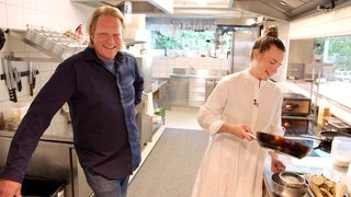 Das Bild zeigt Björn Freitag mit Hauben-Köchin Milena Broger in einer Restaurant-Küche.