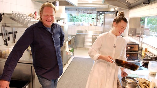 Das Bild zeigt Björn Freitag mit Hauben-Köchin Milena Broger in einer Restaurant-Küche.