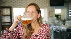 Das Bild zeigt Tamina Kallert, die ein tschechisches Bier probiert.