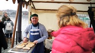 Das Bild zeigt Tamina Kallert im Gespräch mit einem Händler.