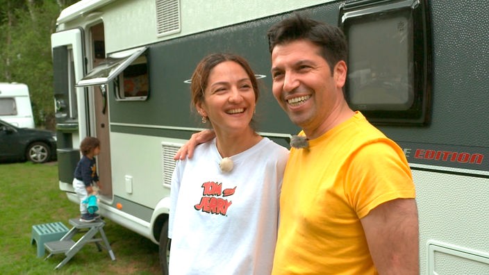 Das Bild zeigt Dery und Mete Karakurt vor ihrem neuen gebrauchten Wohnwagen.
