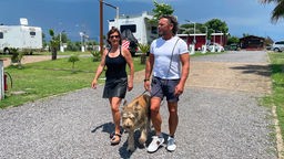 Das Bild zeigt die Protagonisten Britta, Andreas und Hund Toni, die gerade den ersten Stellplatz ihrer Reise erkunden.
