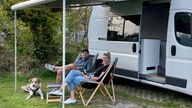 Das Bild zeigt Svenja und Jan vor ihrem Camper.