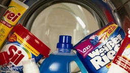 Das Bild zeigt mehrere Waschprodukte in eine Waschtrommel.