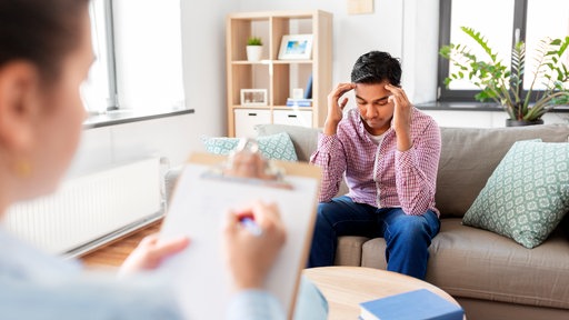 Das Bild zeigt einen Mann bei einer Therapiesitzung.