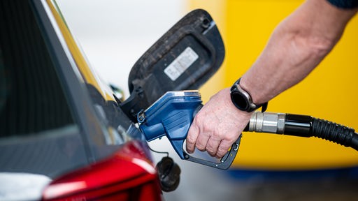 Ein Mann betankt an einer Tankstelle sein Auto.