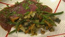 Ein Filetsteak mit Waldpilzen und grünen Böhnchen als Beilage angerichtet