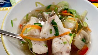 Fischsuppe nach Thai-Art in einem Teller angerichtet