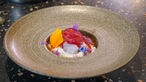 Das Bild zeigt einen Teller mit dem Gericht "Makrele mit Stielmus und marinierten und karamellisierten roten Zwiebeln".