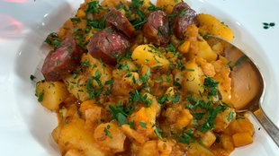 Kartoffelgulasch mit Wurstscheiben in einem Teller