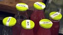 Sechs Flaschen mit Rhabarbergetränken, auf den gelben Deckeln steht die Bezeichnung des Getränks