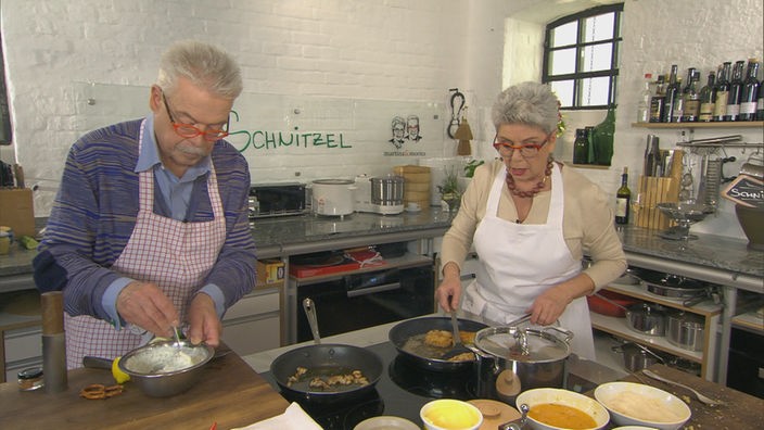 Martina und Moritz bereiten in ihrer Küche panierte Schnitzel in verschiedenen Varianten zu
