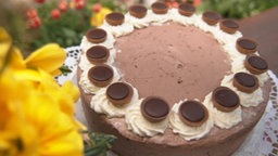 Eine Schoko-Toffee-Torte neben einem Strauß gelber Blumen