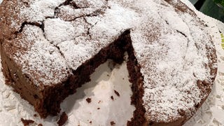 Runder Schokoladenkuchen, angeschnitten auf einer Platte serviert