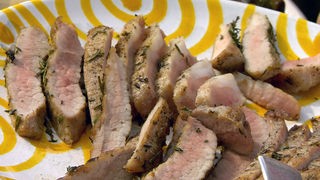 Gegrilltes Schweinefleisch in kleine Stücke geschnitten und auf einer Platte angerichtet