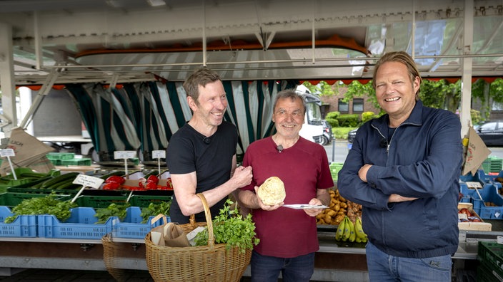  Björn Freitag (r.) kauft mit Udo Jostes (m.) und dessen Schwiegersohn Stefan Jostes (l.) frische Lebensmittel auf dem Wochenmarkt.