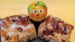 Apfel-Zimtschnecken angerichtet mit einem Marzipan-Apfel mit Gesicht.