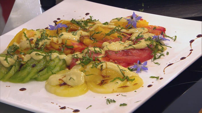 Knoblauch-Senf-Vinaigrette auf Tomaten auf einer Platte angerichtet