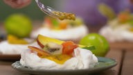 Das Bild zeigt das fertige Dessert Pavlova mit exotischen Früchten.