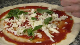 Das Bild zeigt Neapolitanische Pizza mit Basilikum und Mozarella.