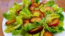 Romana Salat mit gebratenen Pfirsichen fertig angerichtet.