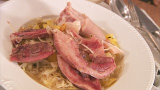 Sauerkraut mit Schnäuzchen und Öhrchen vom Schwein auf einem Teller angerichtet