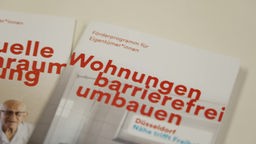 Das Bild zeigt zwei Broschüren zum Thema "Wohnungen barrierefrei umbauen".