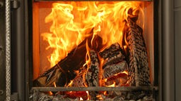 Das Bild zeigt ein Feuer in einem Kaminofen.