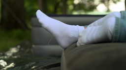 Das Bild zeigt zwei paar Füße auf einer Luftmatratze.