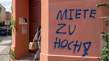 Der Spruch "Miete zu hoch", steht geschrieben an einer Wand.