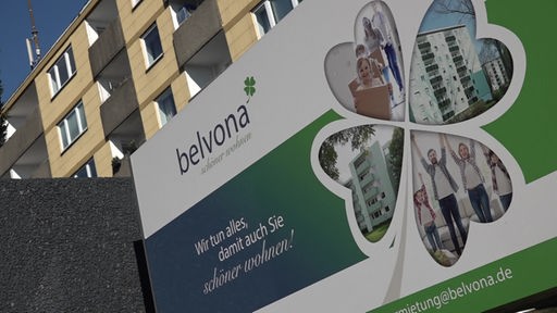 Ein Werbeplakat von Belvona vor einem Mehrfamilienhaus