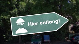 Ein Schild mit der Silhouette eines Einbrechers und den Worten "Hier entlang!"
