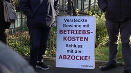 Auf dem Bild sieht man ein Protest-Plakat mit der Aufschrift "Versteckte Gewinne mit Betriebskosten - Schluss mit der Abzocke"