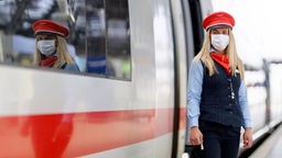 Das Bild zeigt eine Schaffnerin der Deutschen Bahn mit Mundschutz.