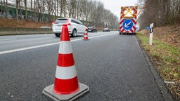 Bauarbeiten auf dem Seitenstreifen A40: Leitkegel im Vordergrund, Baustellenschild mit Pfeil