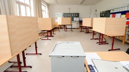 Leere Wahlkabinen stehen in einem Wahllokal in einer Schule