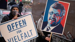 Demonstranten halten zwei Schilder in die Höhe, auf denen der ermordete Kasseler Regierungspräsident Lübacke und die Aufforderung "Offen für Vielfalt" zu sehen sind
